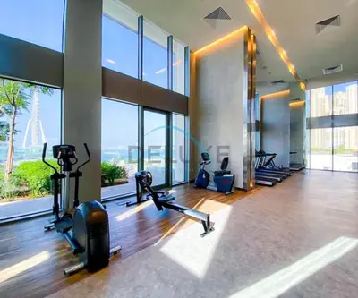 a gym with cardio machines and large windows at Sea View 3BR with Assistant Room and Balcony, Just Steps from Marina Promenade, 5242 Tower 1, Dubai Marina by Deluxe Holiday Homes in Dubai