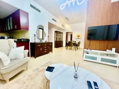 a living room with a couch and a table and a tv at One bedroom apartment available in Front of Marina Beach Dubai in Dubai