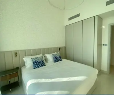 a bedroom with a large white bed with blue pillows at Dubai Harbour in Dubai