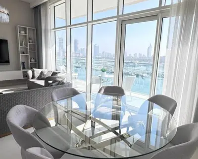 a living room with a glass table and chairs at Dubai Harbour in Dubai