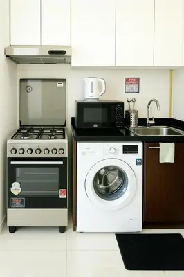 a kitchen with a stove and a washing machine at Dezire Delight in Dubai