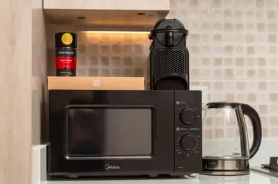 a black microwave sitting on top of a counter at Apartment on Palm Jumeirah Beach Parking in Dubai