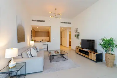 a living room with a couch and a table at Cozy and Stunning Waterfront One Bed in Dubai