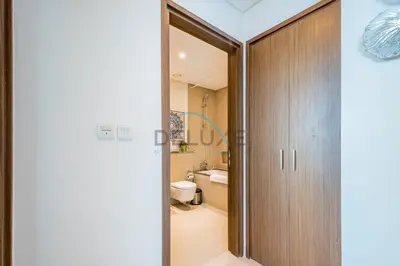 a bathroom with a toilet and a wooden door at Elegant 1BR in 5242 Tower 1, Dubai Marina by Deluxe Holiday Homes in Dubai