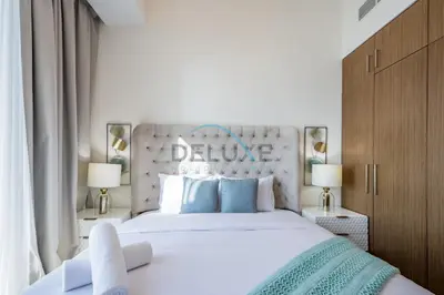 a bedroom with a large white bed with blue pillows at Elegant 1BR in 5242 Tower 1, Dubai Marina by Deluxe Holiday Homes in Dubai
