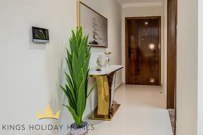 a hallway with a table and a plant next to a door at Luxury 2 Apartments Dunya tower Burj Khalifa St in Dubai