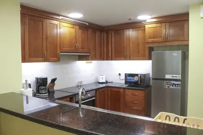 a kitchen with wooden cabinets and a stainless steel refrigerator at Modern Apartment in Dubai Marina in Dubai