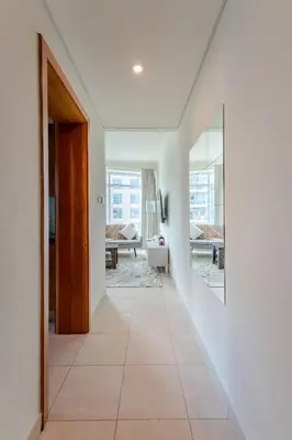 a hallway with white walls and a large mirror at 2BR Luxury Apartment in Downtown Opposite Mall and Fountain Entrance in Dubai