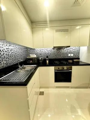 a kitchen with white cabinets and a sink at Samani vacation homes 3018 in Dubai