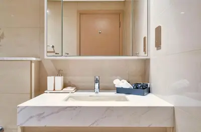 a bathroom with a white sink and a mirror at Urban Zen Sky Suite 1BR - Dubai Mall Access by Maxx Value homes in Dubai