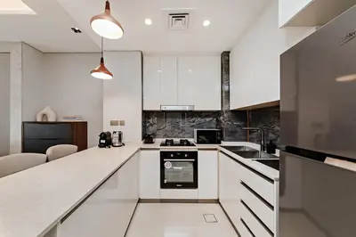 a kitchen with white cabinets and a counter top at 10 Mins to Dubai Mall1BRBusiness Bay Heaven in Dubai