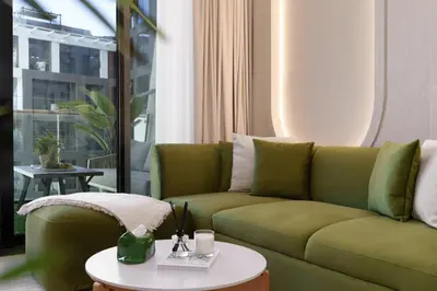 a living room with a green couch and a table at The Burj and Canal Views in Dubai