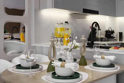 a kitchen with a table with wine glasses and dishes at The Burj and Canal Views in Dubai