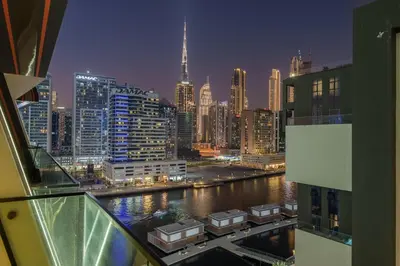 a view of a city at night from a balcony at The Burj and Canal Views in Dubai