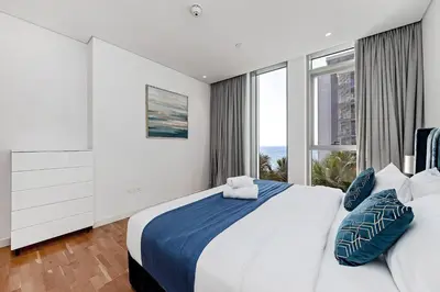 a bedroom with a large bed and a large window at Bluewaters Sea View 2BR Pool & Gym & Beachfront in Dubai