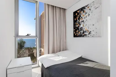 a bedroom with a bed and a large window at Bluewaters Sea View 2BR Pool & Gym & Beachfront in Dubai