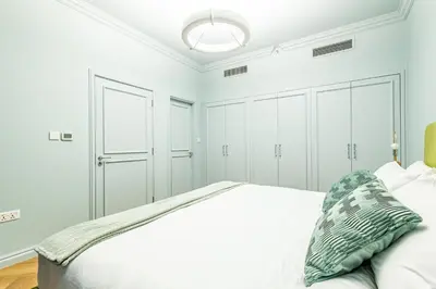 a white bedroom with a bed and white cabinets at Unique JBR Gem - Full Sea View - Designer's Choice - 5 min walk from JBR Beach in Dubai