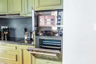 a kitchen with green cabinets and an oven at Unique JBR Gem - Full Sea View - Designer's Choice - 5 min walk from JBR Beach in Dubai