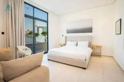 a white bedroom with a bed and a couch at Blue Breeze - Elegant 1BR with Private Jacuzzi & Terrace in JVC in Dubai