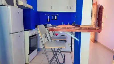 a kitchen with blue walls and a table and chairs at Aesthetic Blue Studio on Marina Walk in Dubai
