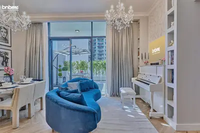 a living room with a blue couch and a piano at bnbmehomes - Oxford Terraces in Dubai