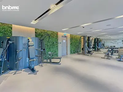 a gym with rows of treadmills and machines at bnbmehomes - Oxford Terraces in Dubai