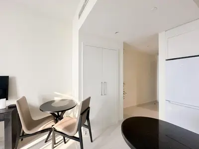 a dining room with a black table and chairs at Bespoke Holiday Homes - High floor studio in Tower 108 JVC in Dubai