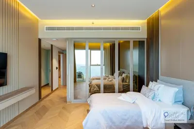 a hotel room with two beds and a television at Luxury Beachfront 3 Bed Apt in Dubai JBR in Dubai