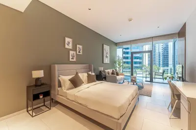 a bedroom with a bed and a living room at HAVN - New Studio Business Bay, Burj Khalifa View in Dubai