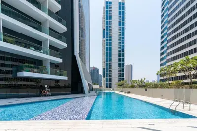 a swimming pool in the middle of a building with tall buildings at HAVN - New Studio Business Bay, Burj Khalifa View in Dubai