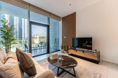 a living room with a couch and a tv and a table at HAVN - New Studio Business Bay, Burj Khalifa View in Dubai