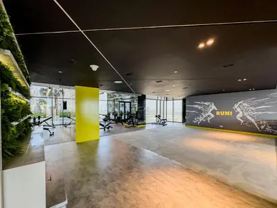 a lobby with a gym with a yellow wall at Higher Floor 2BR in Aykon City Discounted Prices in Dubai