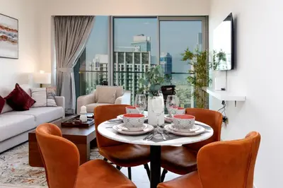 a living room with a table and chairs and a couch at Brand New 1BR Apt in Grande Residence, Downtown Dubai - Allsopp & Allsopp in Dubai