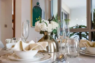 a table with a vase with white roses in it at Durrani Homes - Azure 2BR with Burj Khalifa and Fountain View in Dubai