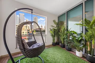 a hanging hammock in a room with plants at Durrani Homes - Azure 2BR with Burj Khalifa and Fountain View in Dubai