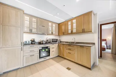 a kitchen with wooden cabinets and an oven at Durrani Homes - Azure 2BR with Burj Khalifa and Fountain View in Dubai