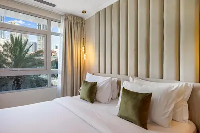 a bedroom with a white bed with pillows and a window at Durrani Homes - Azure 2BR with Burj Khalifa and Fountain View in Dubai