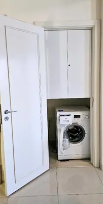 a washer and dryer in a white kitchen at Superb 1 BR apt next to Burj Khalifa and Dubai mall in Dubai