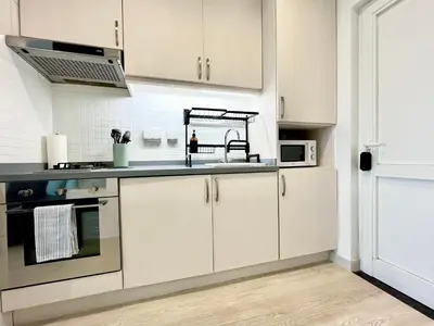 a kitchen with white cabinets and a sink at Boutique Studio in Palm Jumeirah - Stunning View in Dubai