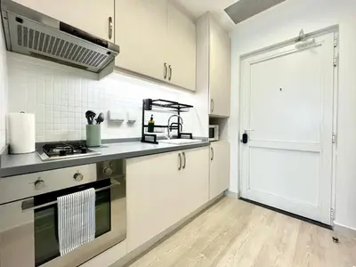 a kitchen with white cabinets and a white door at Boutique Studio in Palm Jumeirah - Stunning View in Dubai