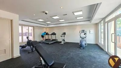 a gym with treadmills and exercise bikes in a room at Vogue The Greens Al Dhafrah near Mall of the Emirates, One Bedroom Apartment with Balcony and vibrant community view, Access to all Amenities in Dubai