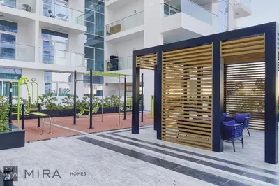 a building with a wooden door in a courtyard at Mira Holiday Homes - Cosy 1 bedroom close to metro Al Furjan in Dubai