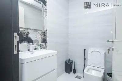 a white bathroom with a sink and a toilet at Mira Holiday Homes - Cosy 1 bedroom close to metro Al Furjan in Dubai