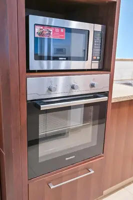 a microwave oven sitting inside of a wooden cabinet at Burj Vista 2BR Luxurious Apartment with Direct Access to Dubai Mall in Dubai