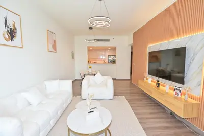a living room with a white couch and a large television at Burj Vista 2BR Luxurious Apartment with Direct Access to Dubai Mall in Dubai