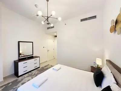 a bedroom with a bed and a television on a dresser at Meydan Marvel Sleek 1-Bedroom Home in Prime Views with Luxe Finishes! by Petals Holiday Homes in Dubai