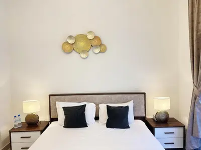 a bedroom with a bed with two night stands and two lamps at Meydan Marvel Sleek 1-Bedroom Home in Prime Views with Luxe Finishes! by Petals Holiday Homes in Dubai