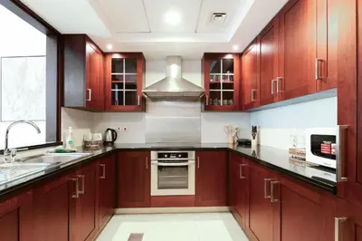 a kitchen with wooden cabinets and a sink at The Boulevard Suite Luxury Burj Khalifa View - Downtown in Dubai