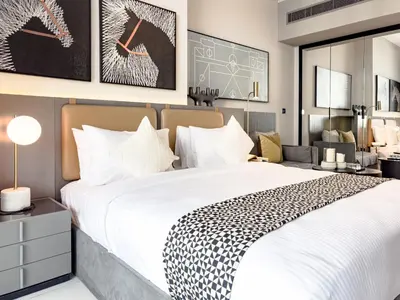 a bedroom with a large white bed and a desk at Select Stay-Studio in MAG 318 - Minutes to Dubai Mall in Dubai