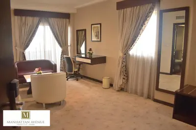 a hotel room with a desk and a chair and window at Manhattan Avenue Hotel in Dubai
